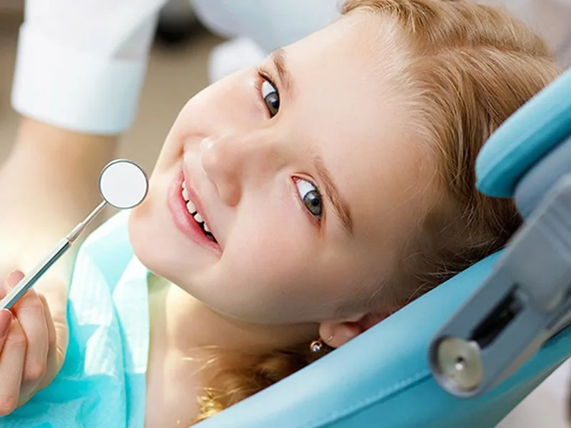 Niña sonriendo en el sillón dental tras una atención de urgencia